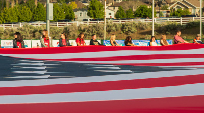 Rodeo attendees helping to hold the giant flag
